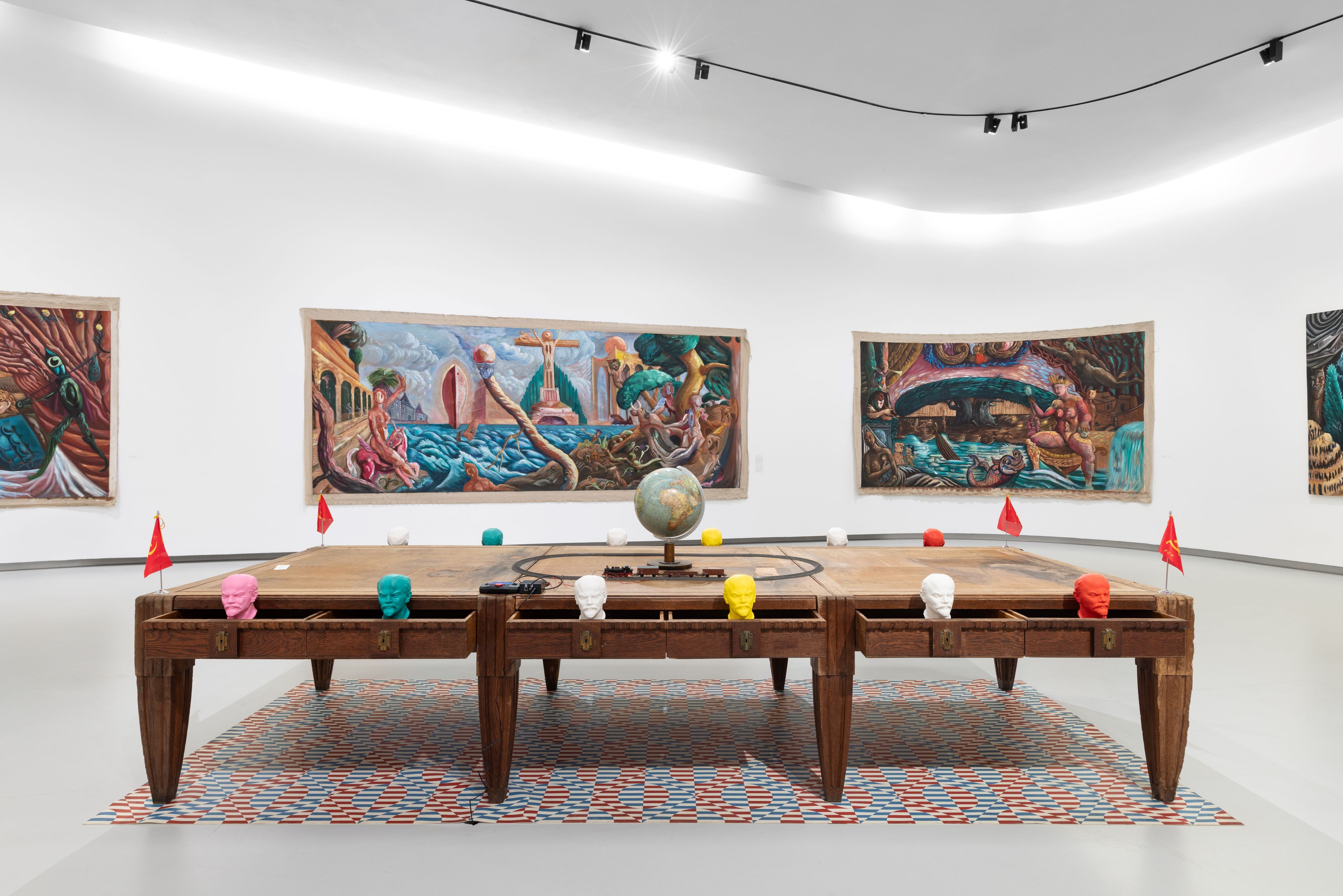 Quadros do artista e mesa com instalação artística